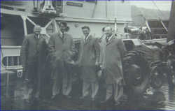 From left: Ron Webster (CB Norwood), Sir Edmund Hillary, J H Miller (nickname Bob) and John Crampton (CB Norwood) in front of the Endeavour.  Ferguson TEA tractor behind, about to be loaded on the ship.