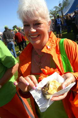 A brightly dressed visitor eats a Festival pie
