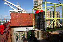 A crane lowers a load of pallets into one of the huge holds on the <em>MV Knud Lauritzen</em>