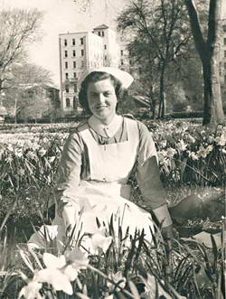 Betty sitting among the daffodils with the �New Nurses Home� in the background.