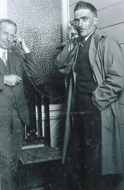 Ralph Cox, the Hokitika postmaster, assists Guy Menzies to ring Sydney with the news.