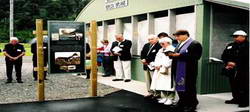 Noted  aviation historian the Reverend Richard Waugh blessing the unveiled plaque Note Guy�s sister and brother, Kathleen and  Bruce, beside the Reverend Waugh, Bruce  Albiston extreme right. Note adjacent hangar, housing replica bi-plane, both constructed from volunteer labour and funding.