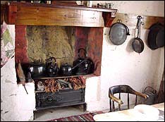 Fireplace in the cob cottage with the pots on the fire for cooking