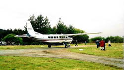 Representatives of the media and dignitaries await the emergence of Dick Smith from his Cessna Caravan aircraft, upon arrival at Harihari.