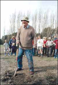 Dr Eric Godley planting a tree